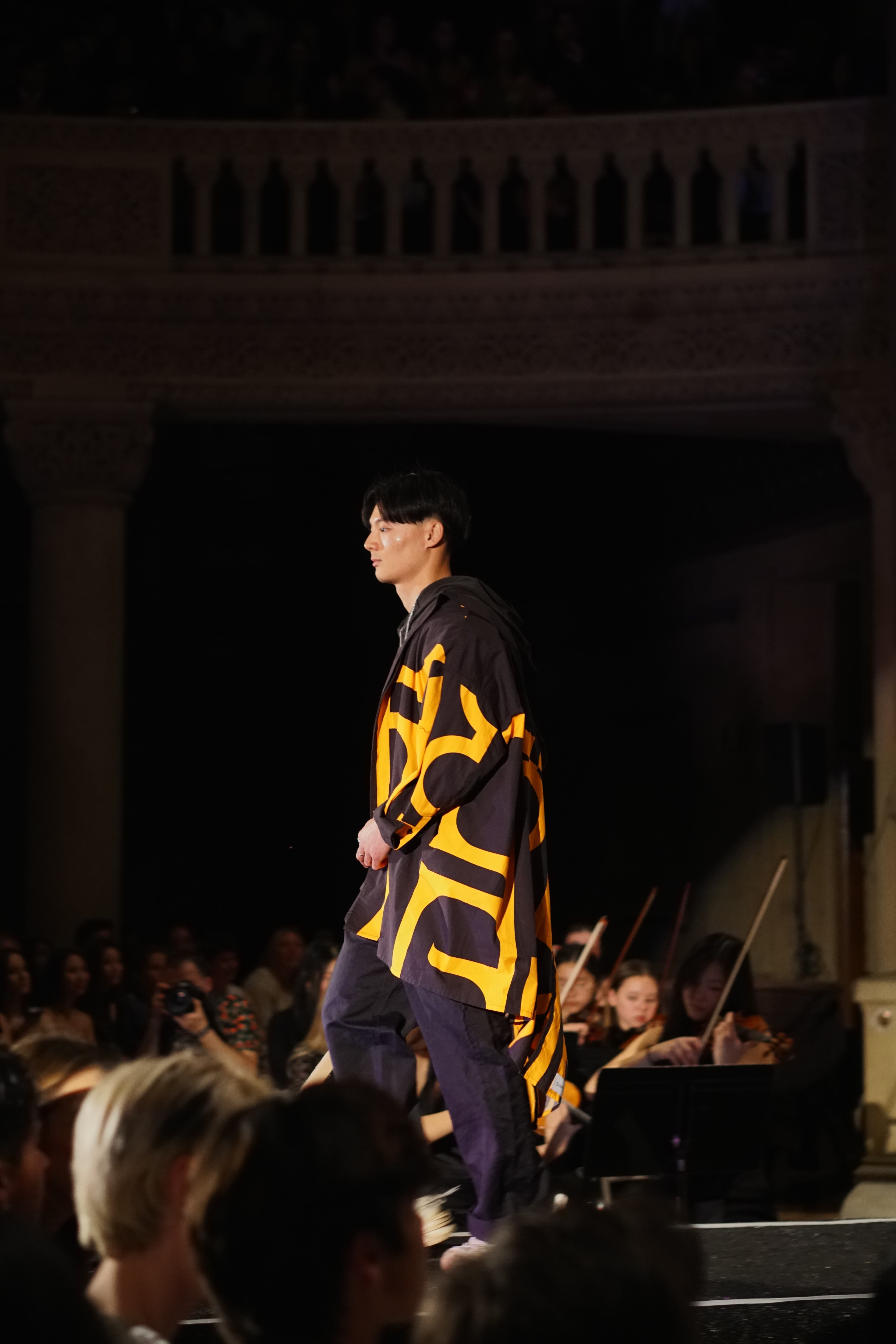 Model in black and yellow graphic hoodie