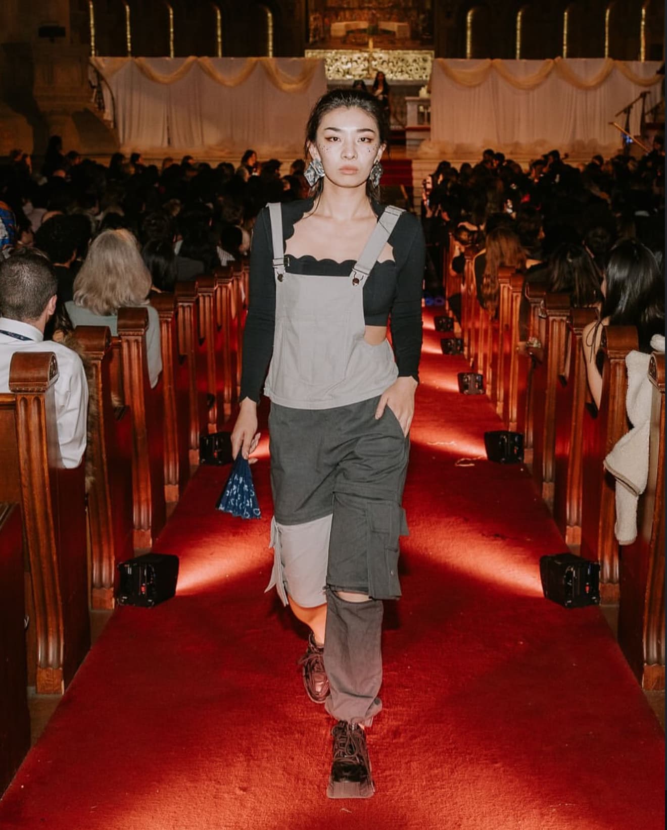 Model in sustainable workwear on red carpet runway